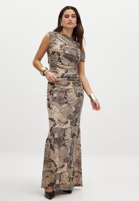 Maxi dress in beige with abstract animal patterns. Asymmetrical neckline, fitted bodice, flowing skirt, and smooth fabric. Black accents and shiny jewelry.
