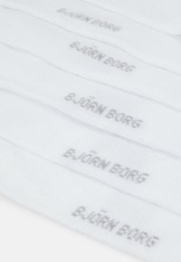 Calcetines deportivos blancos con el texto gris "E. JÖRN BORG" repetido, con una textura suave y forma convencional de calcetín, diseñados para la comodidad y la durabilidad.