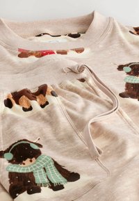 Set de hanorac și pantaloni bej, cu ilustrații jucăușe ale vacilor din Highlands purtând eșarfe și căciuli cu urechi, realizat dintr-un material moale cu manșete cu rezistent.
