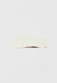 Sål i off-white gummi med teksturert bølgemønster. Rund form med lett krumming på kantene for bedre grep.