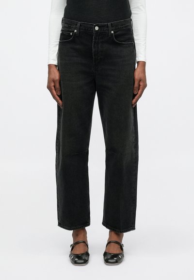 Jeans noirs taille haute à jambes larges en denim, avec poches avant, passants de ceinture et un ourlet brut avec des détails de couture visibles.