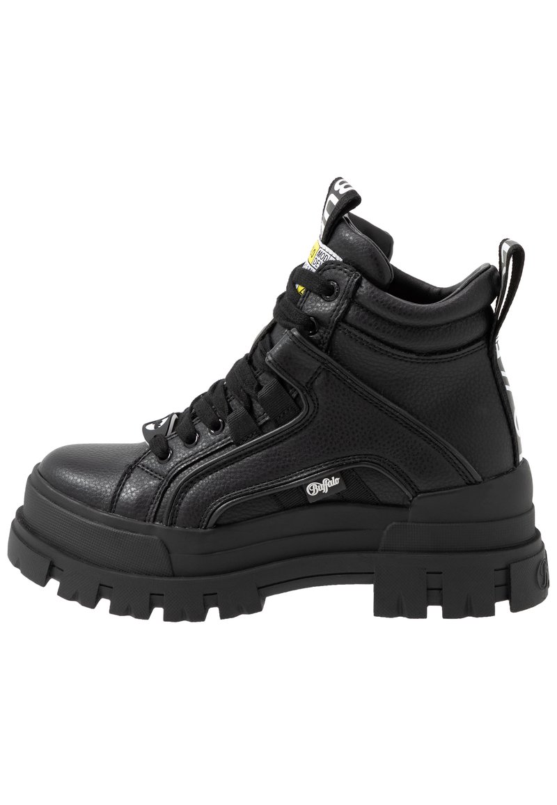 Schwarze Leder-Stiefeletten mit strukturiertem Finish, gepolstertem Kragen, robuster Gummisohle und auffälligem Schnürdesign mit Logo-Details.
