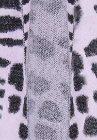 Fekete-fehér kötött textil, amely puha tapintású, csíkos és pöttyös mintázattal rendelkezik, világos és sötét területek kontrasztjával.