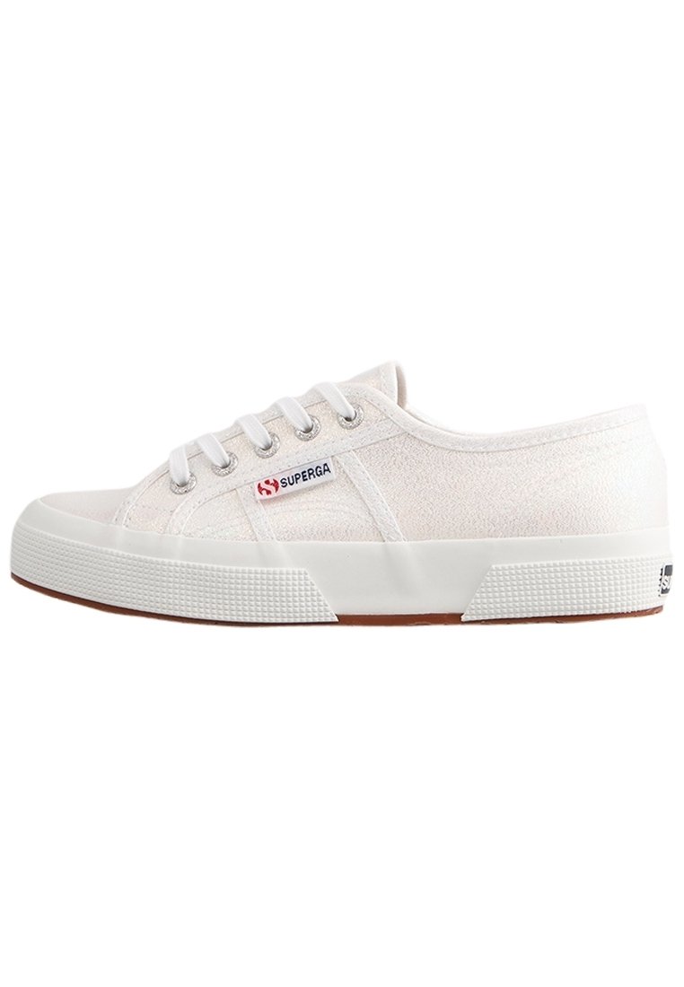 Baskets en toile blanches avec une surface texturée, semelle en caoutchouc blanc et accents marron contrastants. Comprend six œillets et un logo sur le côté.