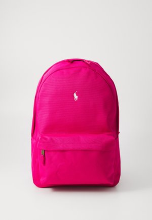Mochila rosa hecha de un tejido duradero, con un compartimento principal con cremallera, un bolsillo frontal y un acento de logo blanco. Forma redondeada con una textura suave.