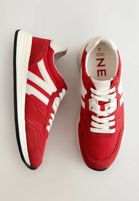 Tenisi roșii cu accente albe, realizati dintr-un amestec de textil și suede, proiectați cu un sistem de închidere cu șireturi și un guler căptușit.