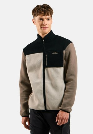 Fleece jacket featuring a black upper, beige lower, and brown sleeves. Includes zippered chest pocket and embroidered logo on front.