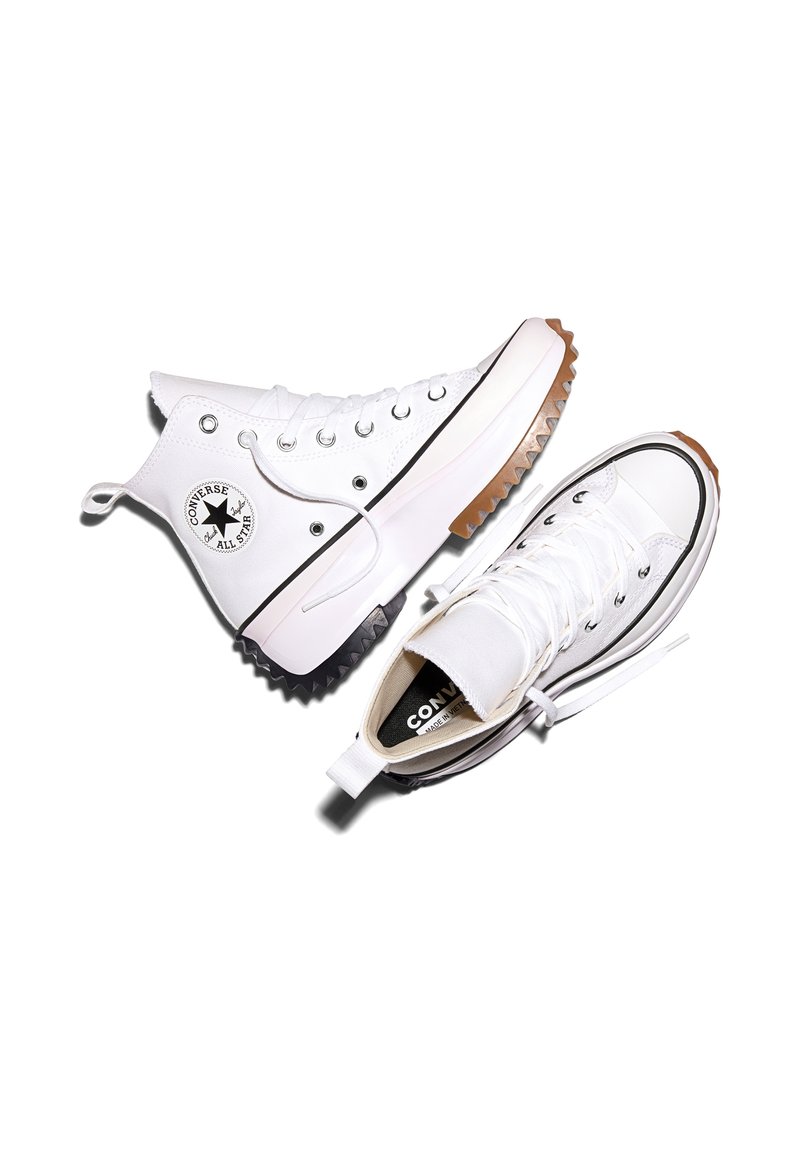 Baskets blanches Converse All Star montantes avec semelles épaisses et striées en noir et marron, vues de côté et de dessus sur fond blanc.