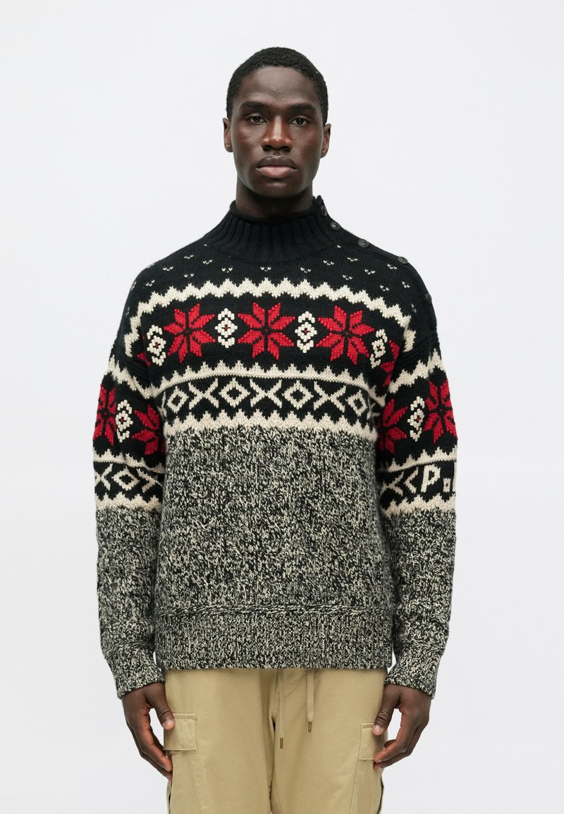 Crni pleteni pulover s crvenim i bijelim geometrijskim uzorcima. Ima rebrasti izrez i uzorkaste rukave. Mekana tekstura.