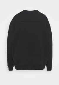 Felpa nera caratterizzata da scollo rotondo, maniche lunghe e orlo a coste. Il tessuto strutturato presenta cuciture ridotte al minimo e una finitura liscia.