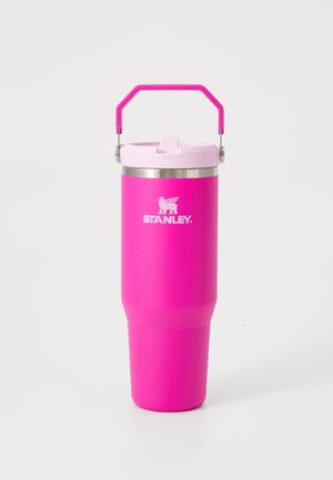Tasse de voyage isolée Stanley de couleur rose vif avec un couvercle rose clair et une poignée assortie, présentée sur un fond blanc uni.