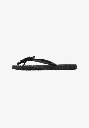 Sort flad vævet sål flip-flop sandal med tynde stropper og en flettet blomster detalje på toppen, sidevisning på hvid baggrund.