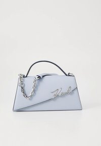 Világoskék kézitáska strukturált kialakítással, ezüst lánc pánttal és a „Karl” felirat írott betűtípussal az elején. Simább bőrhatás.