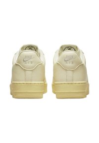 Sneaker Nike Air in pelle crema, con collo imbottito, suola in gomma testurizzata e logo in rilievo sul tallone.