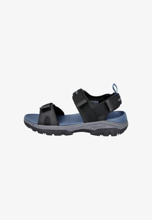 Sandalia negra y azul con puntera abierta, correas de velcro ajustables y suela resistente diseñada para uso en exteriores.