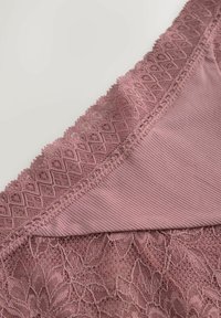 Bralet roz din dantelă, cu modele florale intricate, textură ribbată și margini ondulate la guler și subbandă.