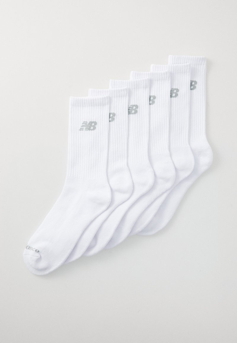 Six paires de chaussettes de sport blanches disposées soigneusement, chacune portant un logo gris subtil de la marque New Balance.