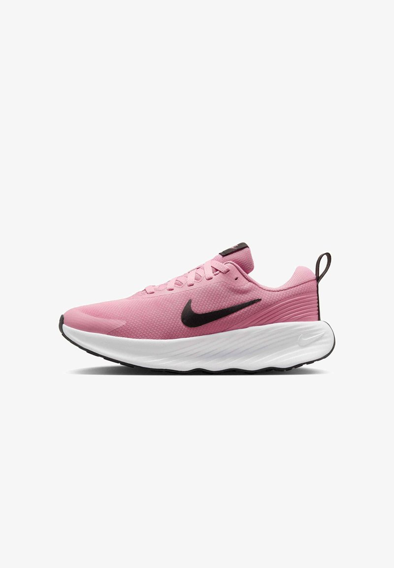 Zapatilla deportiva rosa con parte superior de malla texturizada, swoosh negro de Nike y suela intermedia blanca gruesa. Cuenta con cordones planos y una pestaña en el talón.