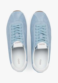 Niebieskie zamszowe sneakersy z płaskimi sznurowadłami, białymi akcentami na języku oraz wewnętrznej wyściółce, a także zaokrąglonym czubkiem.