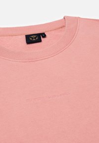 Roze sweatshirt met een ribbelneklijn, een zachte textuur en een reliëf logo "TOMORROWLAND" op de voorkant. Het label geeft maat L aan.