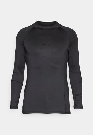 T-shirt de sport noir à manches longues avec col rond et logo central discret sur la poitrine, présenté sur un fond clair uni.