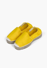 Kollase lõuendiga espadrillid, millel on lame tald, ümarad varbad ja valge õmbluse detail. Loomulik jute köis rõhutab talda.