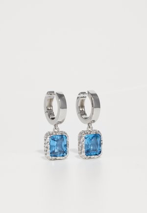 Silver hoop earrings with hammered square frames holding faceted bright blue gemstones, shown against a white background.