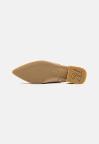 Pointed-toe shoe with a beige suede upper and rubber sole. Features a flat heel and embossed logo on the sole, providing a sleek design.