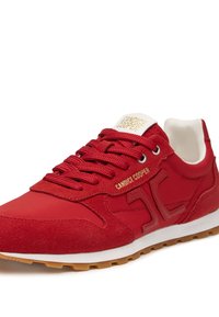 Scarpa da ginnastica rossa realizzata in suede e pelle liscia, con un interno bianco, lacci rossi e brandizzazione dorata sulla linguetta.