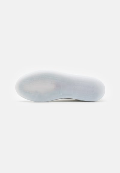 Suela de zapatilla de goma blanca con patrón de agarre texturizado y ligero arco. Acabado suave con sutiles acentos tonales cerca del talón.