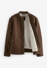 Brūns mākslīgā zamšā sastāvošs mums, ar mīkstu baltu vilnas oderi, stāvošu apkakli un ar rāvējslēdzējiem sānu kabatām. Rāvējslēdzēja aizdare un gluda tekstūra.