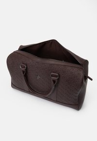 Brown leather duffel bag with embossed logo pattern, rounded shape, dual handles, and top zip closure, showcasing a smooth texture.
