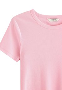 T-shirt rosa chiaro a coste con maniche corte, scollo rotondo e sottili righe verticali. Etichetta del marchio visibile all'interno del collo.