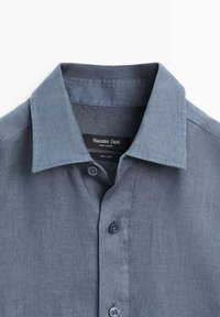 Blauw linnen overhemd met knopen en een puntige kraag, met het merkembleem "Massimo Dutti" zichtbaar aan de binnenkant van de halslijn.