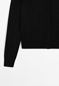 Black cardigan featuring a front button closure, long sleeves, and a straight cut, laid flat against a white background.