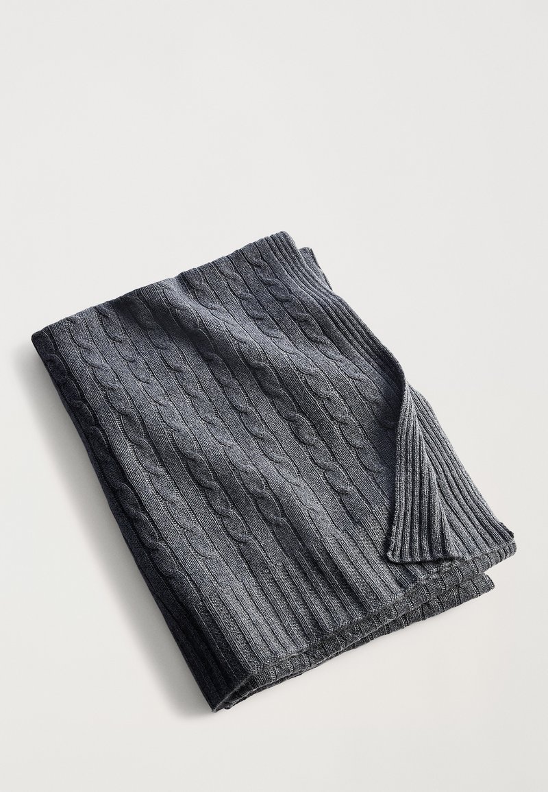 Mantinha tecida de cor cinza escuro com um design ribassado texturizado e padrão de ponto de cable, dobrada de forma organizada para exibir suas bordas.