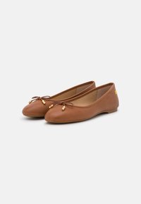Hnědé kožené baleríny s kulatou špičkou, které mají na přední straně mašličku a zlaté akcenty. Nízký profil s flexibilní podrážkou.