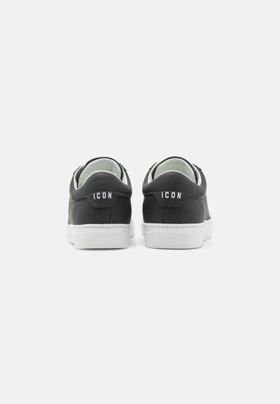Sneaker nere in pelle con suole e dettagli in gomma bianca. La vista posteriore mostra il logo "ICON" sul tallone e cuciture a contrasto.