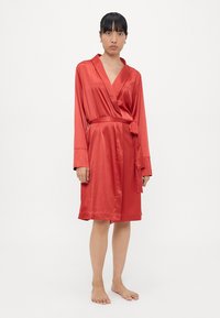 Red satin robe with long sleeves, cinched waist tie, and a smooth texture. Falls mid-thigh, featuring a classic wrap design.