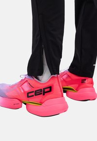 Pink running shoes with a mesh upper and black accents. Features a thick sole with yellow detail and prominent “CEP” branding on the heel.