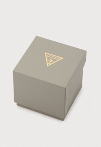 Grijze geribbelde geschenkdoos met gouden driehoekig logo; vierkante vorm met een textuur oppervlak en een bovenzijde met flapsluiting.