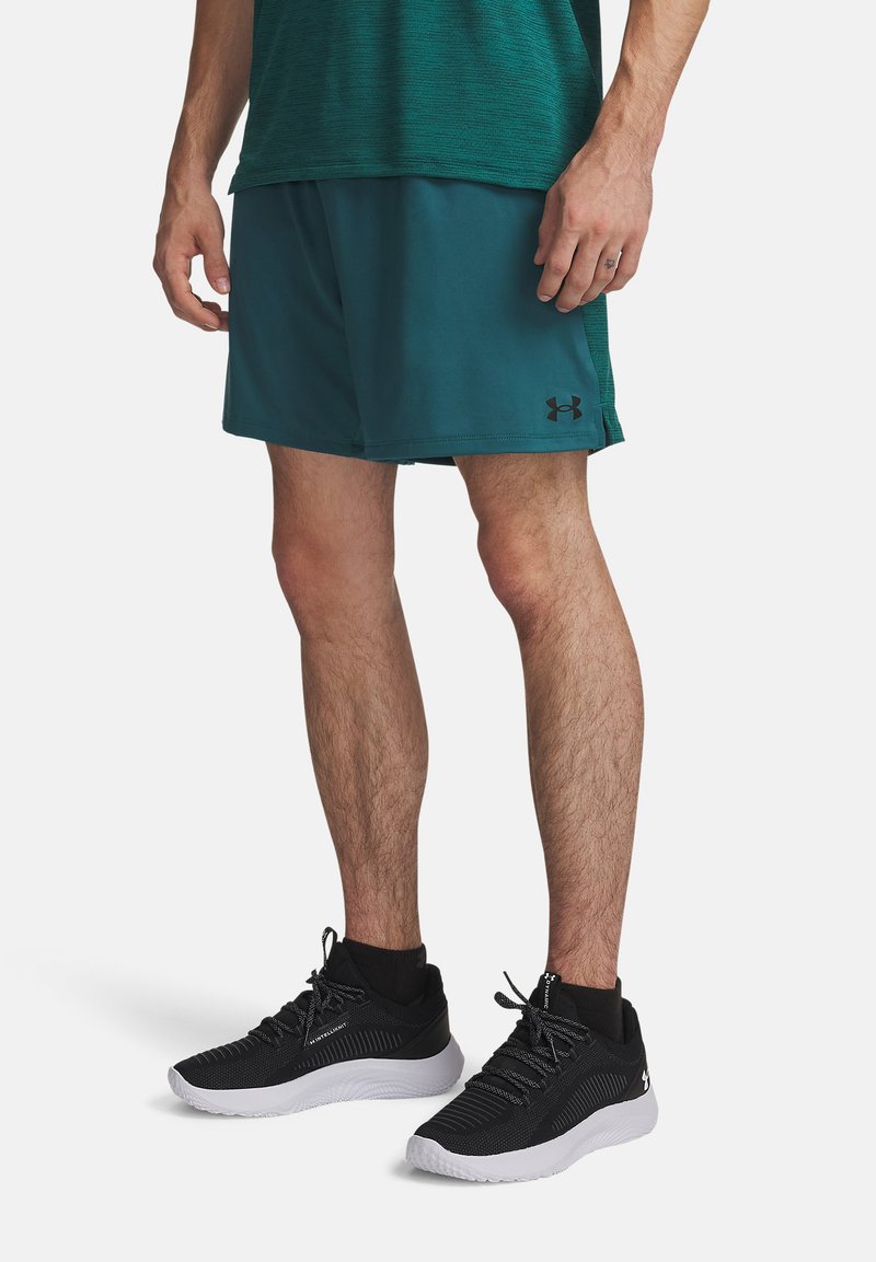 Τιρκουάζ αθλητικά σορτς από υλικό που απομακρύνει την υγρασία, σε συνδυασμό με μαύρα ελαφριά παπούτσια τρεξίματος με λευκές σόλες και ανάγλυφη επάνω επιφάνεια.