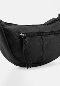 Borsa in pelle nera con forma curva, caratterizzata da una tasca con zip e dettaglio a nappina. La superficie testurizzata aggiunge dimensione al design.
