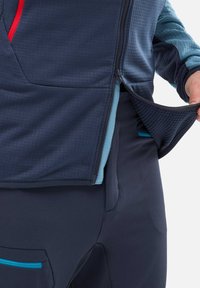 Jacket with a textured navy exterior and light blue interior, featuring a zippered front and pocket with turquoise accent detailing.