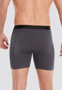 Gray cotton boxer shorts with a black waistband, featuring a snug fit and smooth texture. Displayed from the back view.