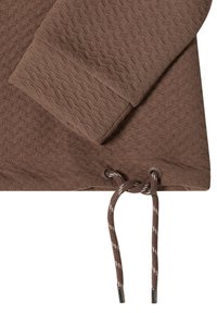 Felpa marrone con texture, con polsini a costine, dotata di un cordoncino all'orlo e di terminali metallici. Il tessuto presenta un delicato motivo a rombi.