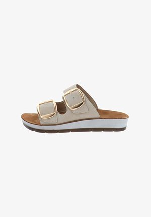 Sandale beige à enfiler avec deux grandes boucles dorées, semelle intérieure en daim, semelle plateforme blanche et semelle extérieure en caoutchouc marron.