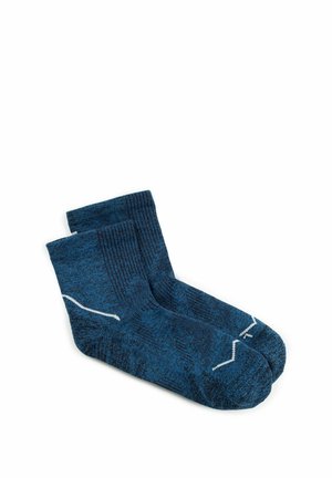 Par de calcetines tobilleros azules con puños acanalados y patrones ondulados blancos sobre fondo blanco.