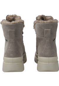 Graue Wildleder-Stiefeletten mit einem flauschigen Futter, strukturierten Oberflächen und einer klobigen, hellen Gummisohle sowie einer Schlaufe auf der Rückseite.