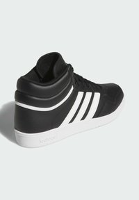 Zapatilla alta negra de material sintético, con tres rayas blancas, un cuello acolchado y una suela de goma blanca.